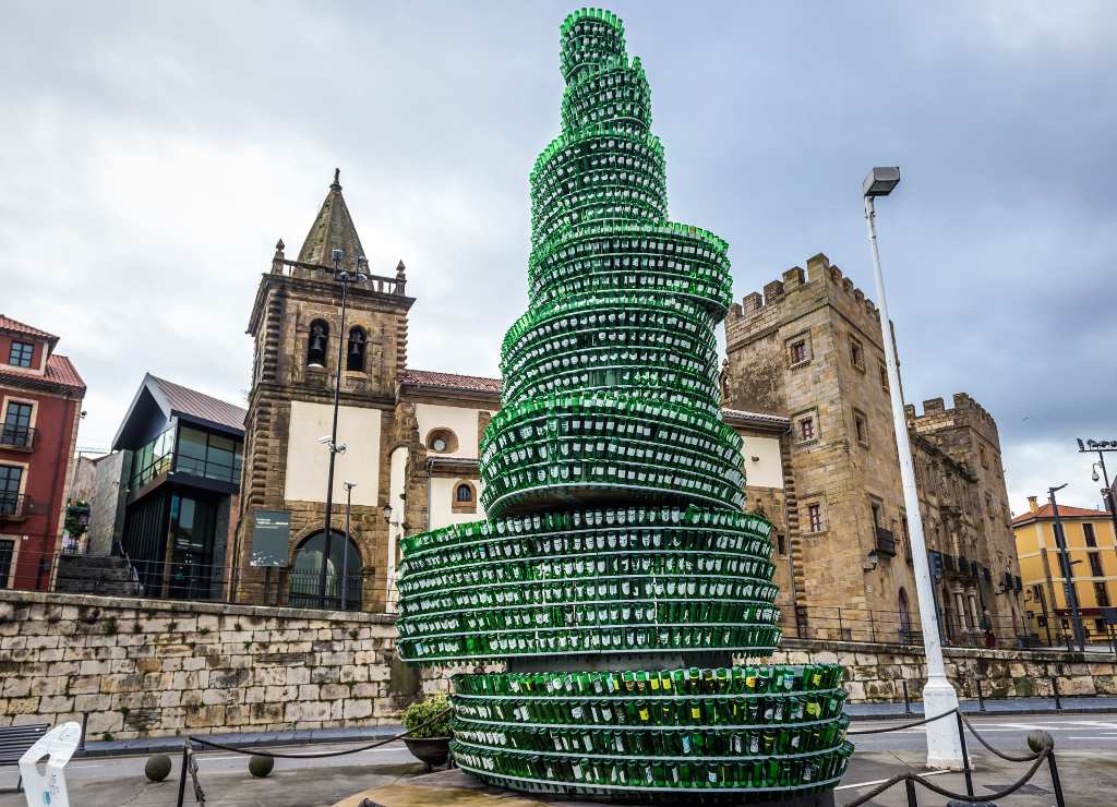 Una de las imágenes más típicas de Gijón es el Árbol de la Sidra hecho con botellas recicladas.