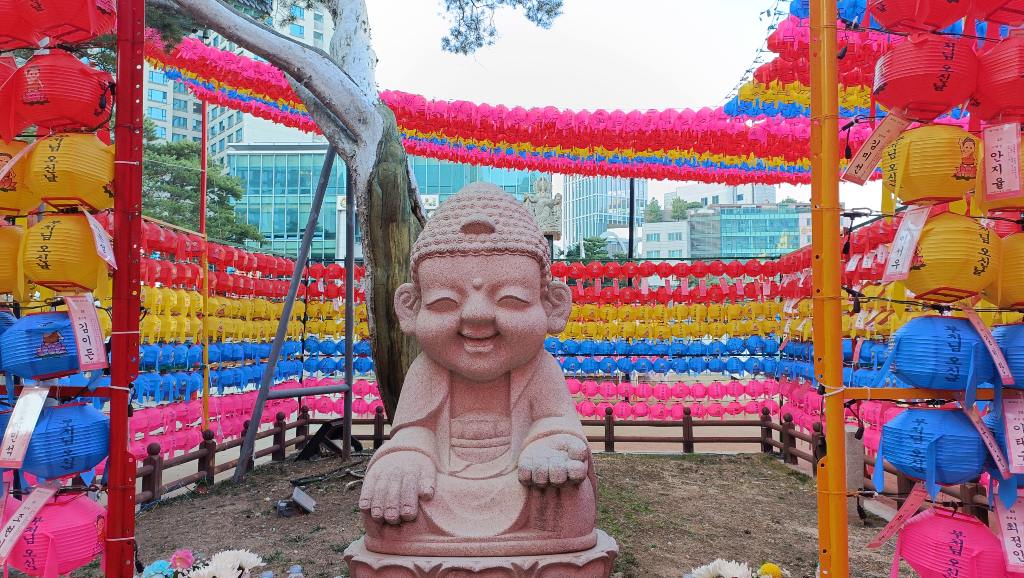 Estatua budista rodeada de farolillos de colores en un templo de Seúl durante un viaje a Corea del Sur.