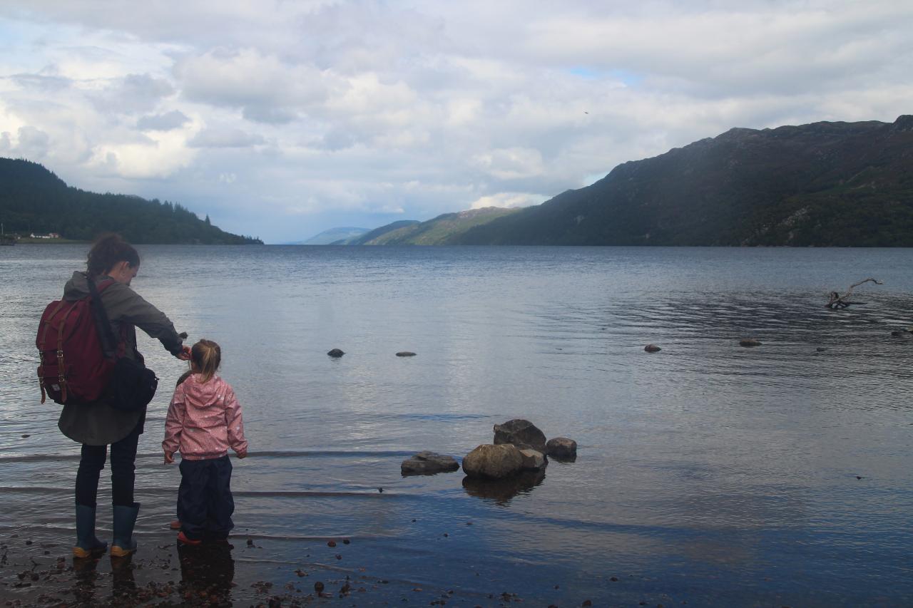 Madre e hija paseando por la orilla del lago Ness en Escocia.